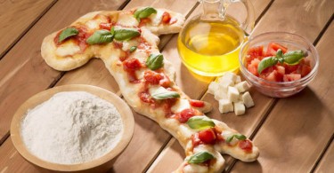 Italia a forma di pizza che racchiude le sigle dei prodotti di qualità DOP IGT