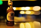 Birra bianca: bottiglia di Hoegaarden su sfondo con gioco di luci - Enjoy Food & Wine